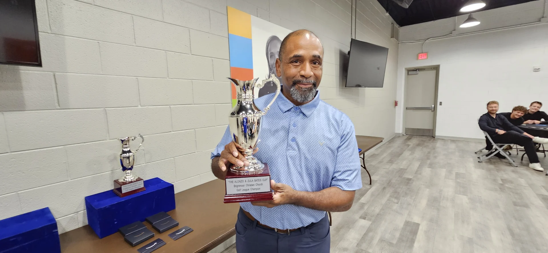 A 2026 Alonzo and Zula Bates Cup champion holding the trophy at the league banquet